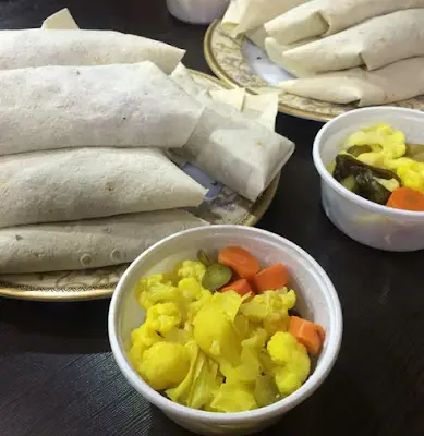 چند لقمه و ساندویچ خوشمزه و تازه از رضا لقمه به همراه دو کاسه ترشی مخلوط زرد رنگ. بهترین انتخاب برای یک وعده غذای سریع و با کیفیت.