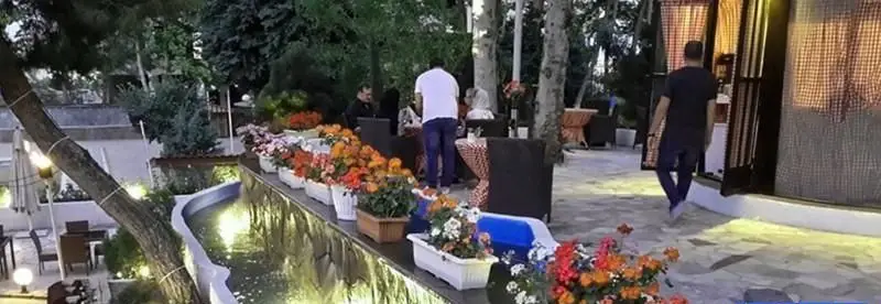 رستوران و کافه فضای باز آبشار گیله وا با آبنمای زیبا، گلدان‌های رنگارنگ و محیطی دلنشین برای صرف غذا و نوشیدنی.