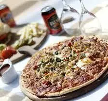 پیتزای تازه پخته شده با مواد اولیه مرغوب و نوشیدنی‌های خنک در فضای دنج کافه رستوران مراکشی حریرا، مناسب برای جمع‌های دوستانه.