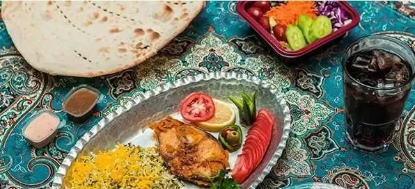 سفره خانه سنتی باغچه: چلو ماهی لذیذ با برنج زعفرانی و سبزی، نان داغ، سالاد تازه و نوشیدنی در محیطی سنتی و دلنشین.