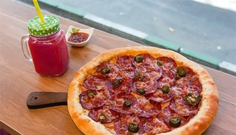 پیتزای پپرونی و هالاپینو لذیذ پیتزایی بلا با کراست طلایی، به همراه نوشیدنی خنک و سس مخصوص، انتخابی عالی برای لذت بردن از غذای ایتالیایی.