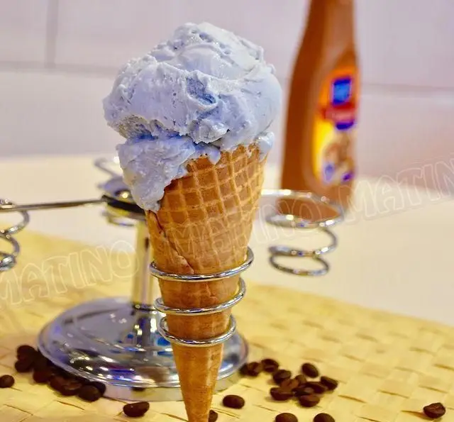 جلاتو آبی روشن و خوشمزه کافه جلاتو متینو در قیف ترد، همراه با دانه های قهوه و سس شکلات. تجربه طعمی خاص.