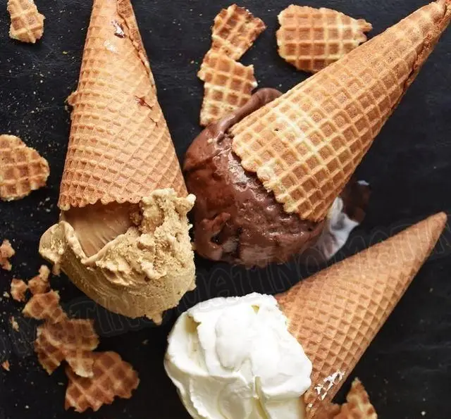 تصویری جذاب از بستنی جلاتوهای خوشمزه کافه جلاتو متینو؛ قیف‌های شکلاتی، وانیلی و کاراملی با تکه‌های ویفر.