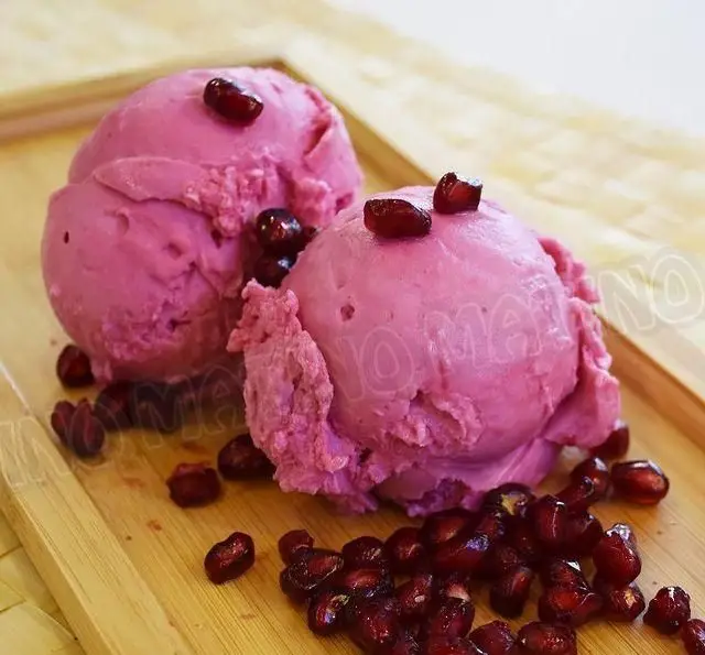 تصویری جذاب از دو اسکوپ جلاتو انار تازه و خوشرنگ کافه جلاتو متینو، سرو شده با دانه های درخشان انار.