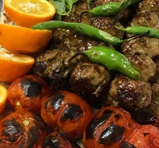 جگرکی گل یخ: بشقاب کباب گوشت و کوبیده لذیذ با فلفل سبز کبابی، گوجه فرنگی بریان و پرتقال تازه. غذای سنتی ایرانی.