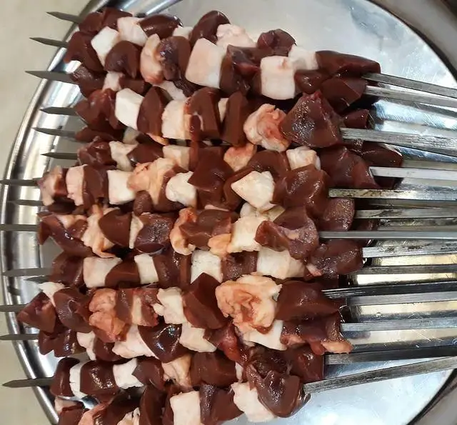 نمایی از سیخ‌های جگر و چربی گوسفندی تازه، آماده کباب شدن در جگرکی گل یخ، تجربه‌ای لذیذ از غذای اصیل ایرانی.