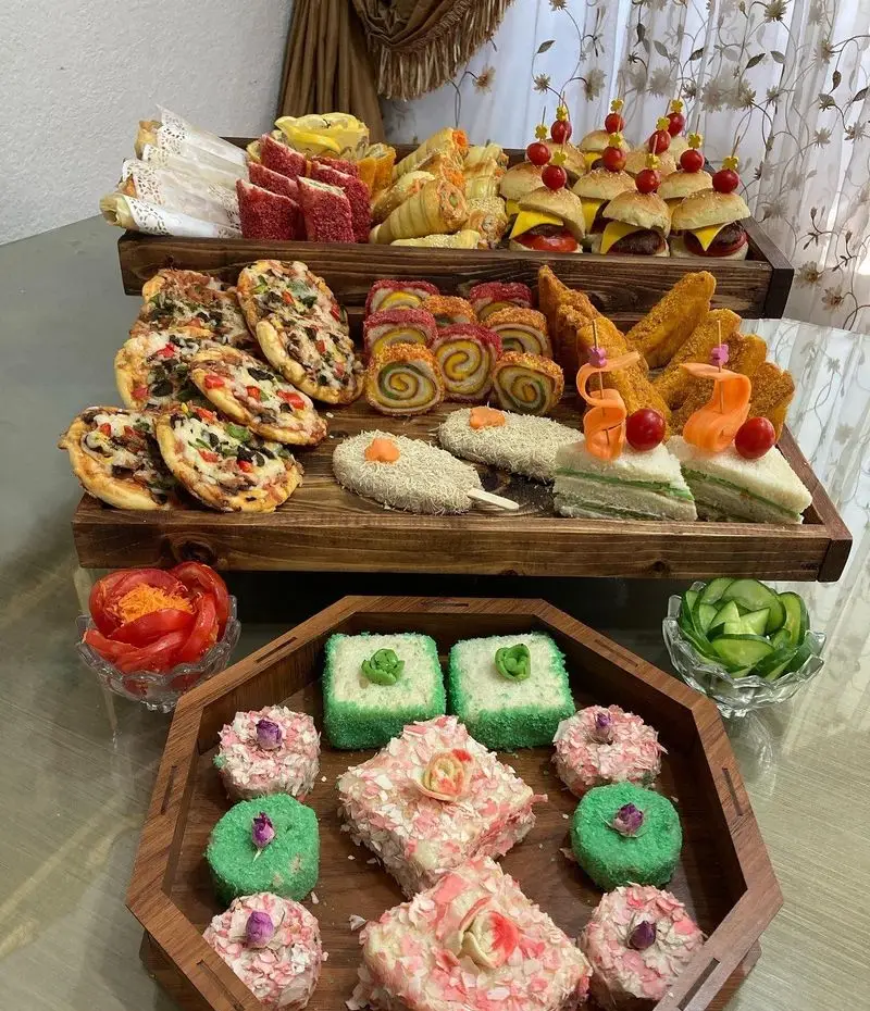 سینی فینگر فود متنوع فینگر لند شامل مینی پیتزا، همبرگر، شیرینی و مزه برای پذیرایی مهمانی و تولد شیک و مدرن.