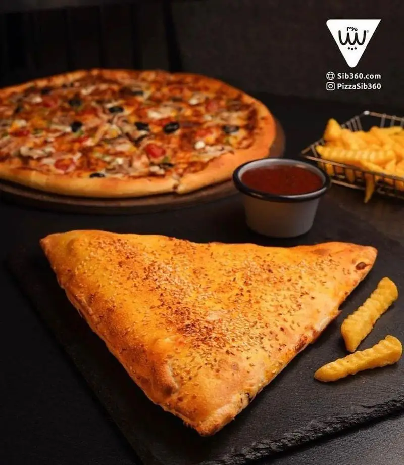 تصویر جذاب از پیتزا، کاله مثلثی طلایی، سیب زمینی سرخ کرده و سس قرمز در فست فود سیب ۳۶۰. غذایی خوشمزه و با کیفیت.