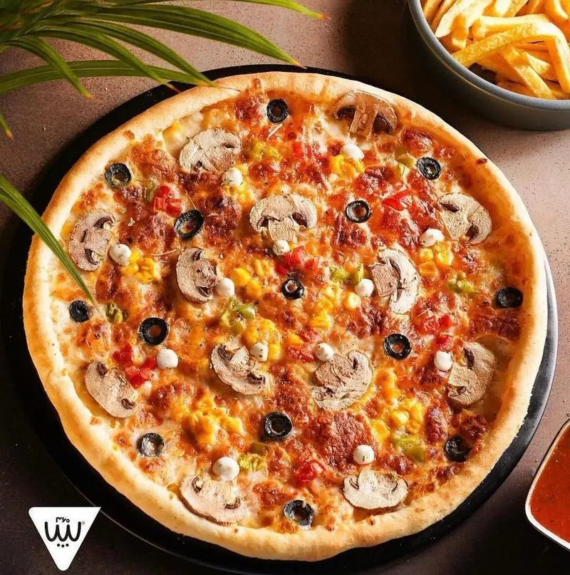 پیتزای سبزیجات خوش طعم و تازه سیب ۳۶۰ با قارچ، زیتون، ذرت و فلفل دلمه، در کنار سیب زمینی سرخ کرده ترد و سس مخصوص.