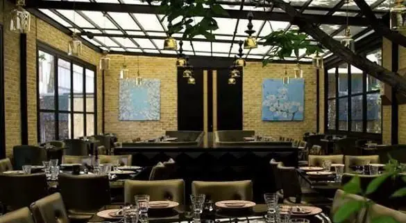 رستوران غذای دریایی سیتادل: محیطی لوکس و مدرن با سقف شیشه ای، دیوارهای آجری، تابلوهای هنری و چیدمان زیبای میزها