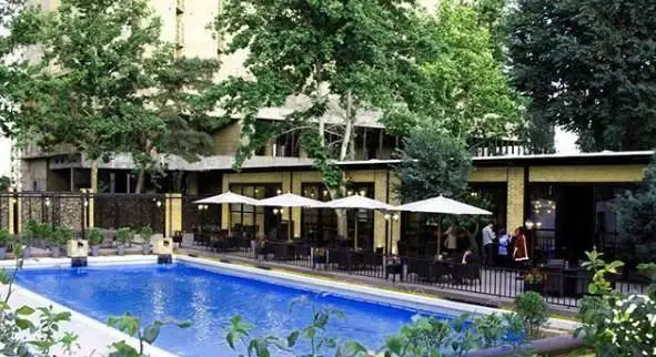 فضای چشم‌نواز رستوران غذای دریایی سیتادل با استخر روباز، چترهای سفید و میزهای شیک در محیطی سرسبز، ایده‌آل برای لذت بردن از غذای دریایی.