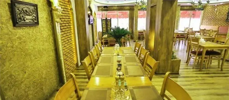 فضای داخلی رستوران فرنگی آریل با دکوراسیون گرم و دلنشین، شامل میز و صندلی‌های چوبی و طراحی سنتی برای تجربه‌ای آرامش‌بخش.