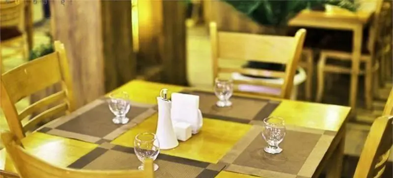 نمایی دنج و گرم از فضای داخلی رستوران فرنگی آریل، با میز و صندلی‌های چوبی چیده شده و آماده پذیرایی از میهمانان عزیز.