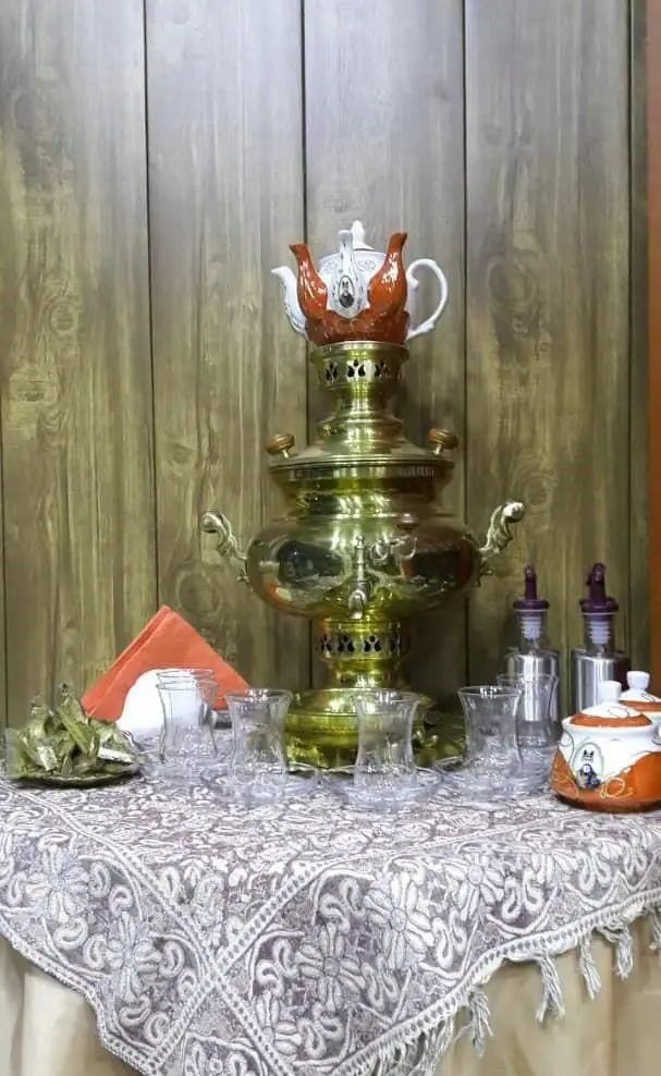 پذیرایی چای با سماور برنجی و استکان‌های سنتی در فضای دلنشین رستوران ماهان درباری، تجربه‌ای بی‌نظیر.