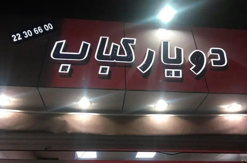نمای شبانه رستوران دویارکباب با تابلوی روشن و شماره تماس 22306600، ارائه‌دهنده بهترین کباب‌ها و غذاهای اصیل ایرانی.