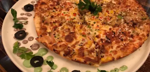پیتزا میلاد: پیتزای مخصوص با کنجد، ذرت، فلفل دلمه و زیتون روی سس‌های خوشمزه، انتخابی عالی برای دوستداران پیتزا.