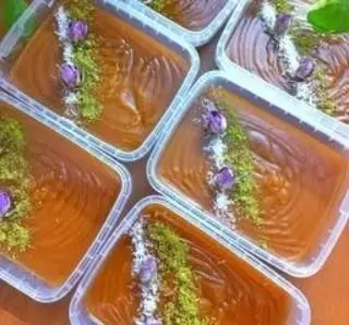 ظروف دسر حلوا یا حریره با تزیین پودر پسته و غنچه گل محمدی، آماده سفارش از فینگرفود تهران خاورشهر. دسرهای شیک مجلسی.