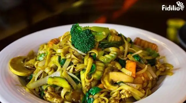 نودل‌های پهن سرخ شده با سبزیجات تازه شامل بروکلی، هویج و قارچ در رستوران چینی اژدهای طلایی.