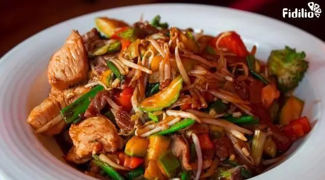 یک بشقاب بزرگ از مرغ تفت داده شده با سبزیجات تازه شامل فلفل دلمه‌ای، کلم بروکلی و جوانه ماش از رستوران چینی اژدهای طلایی