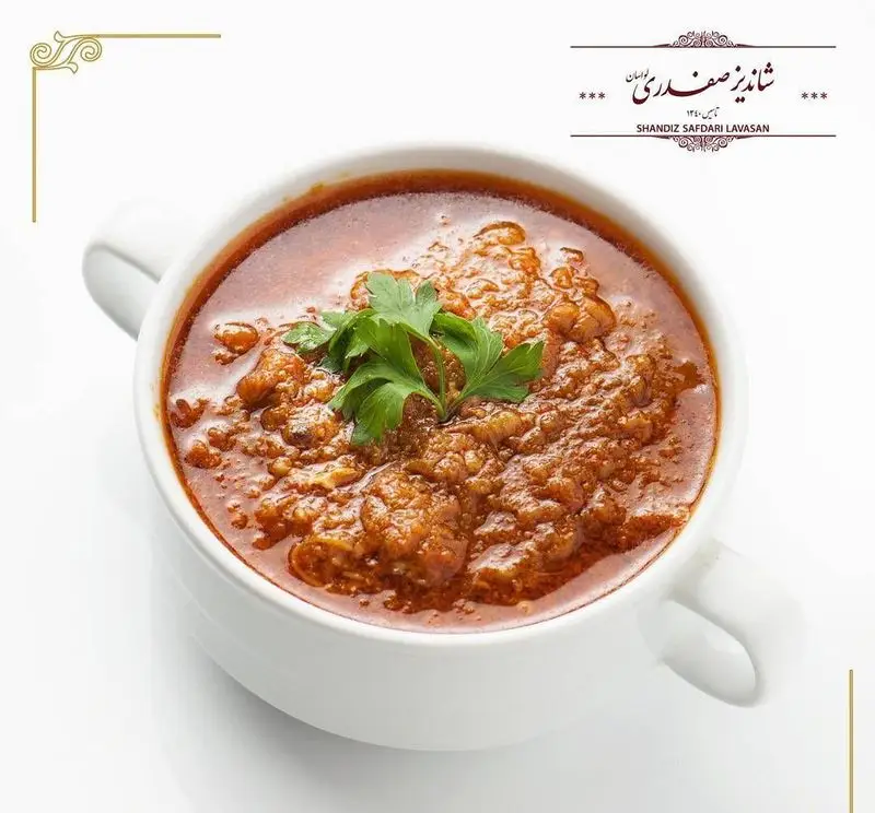 کاسه‌ای از خورشت سنتی و خوشرنگ ایرانی رستوران شاندیز صفدری لواسان، با تزئین سبزی تازه، نمادی از طعم و کیفیت عالی.