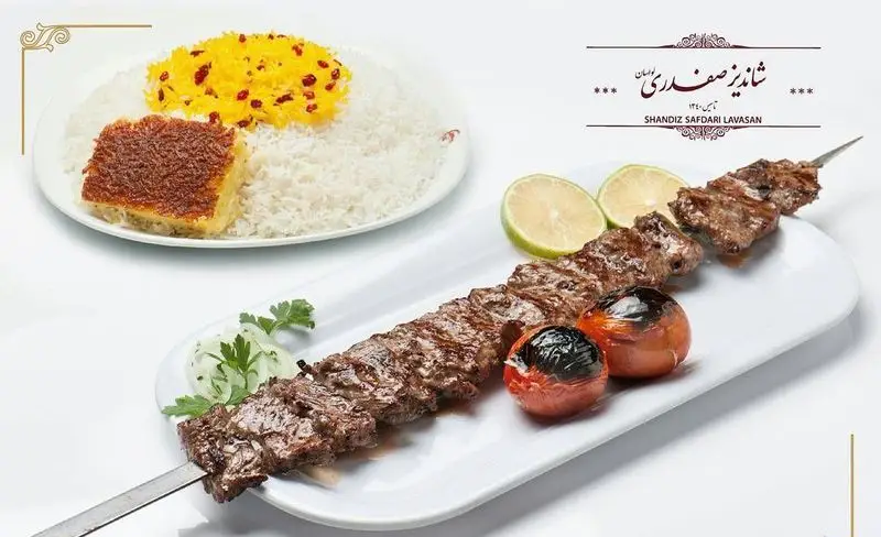 تصویری جذاب از کباب برگ لذیذ رستوران شاندیز صفدری لواسان با برنج زعفرانی، ته دیگ طلایی، گوجه و لیمو. غذای اصیل ایرانی.