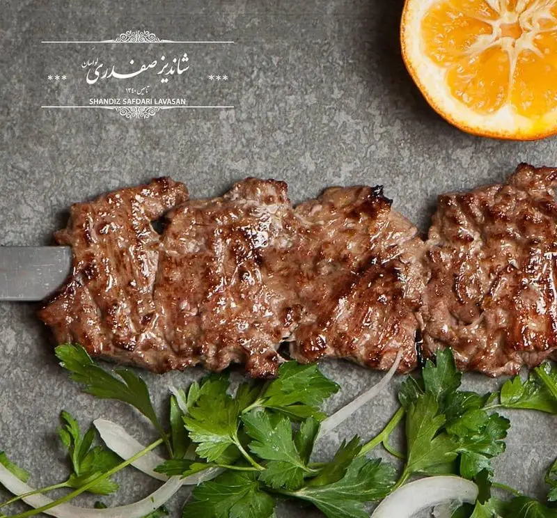 کباب لذیذ و اصیل ایرانی رستوران شاندیز صفدری لواسان، همراه با سبزیجات تازه و تکه نارنج. تجربه‌ای خوش طعم از بهترین کباب‌ها.
