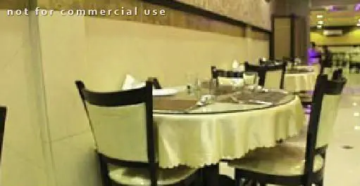 فضای داخلی دنج و شیک رستوران اکبر جوجه شعبه چهارراه ولیعصر، آماده پذیرایی از مشتریان با میز و صندلی‌های آراسته.