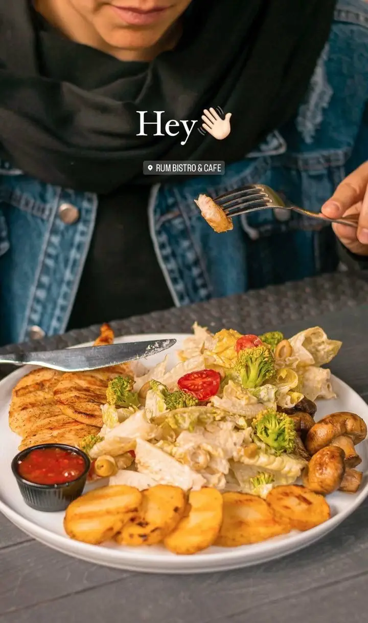 مشتری در کافه رام بیسترو، از غذاهای متنوع شامل سینه مرغ گریل، سالاد تازه، سیب زمینی و قارچ لذت می‌برد. تجربه غذایی عالی در کافه بیسترو رام.