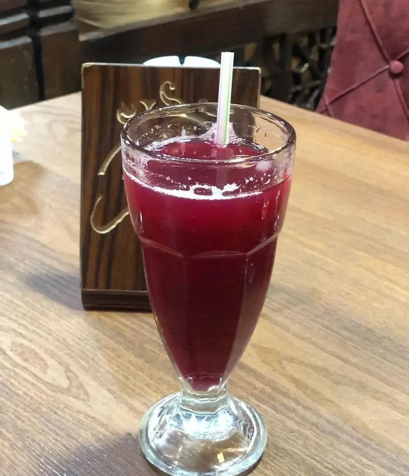 آبمیوه طبیعی و تازه با رنگ جذاب در سفره خانه سنتی دیزی نار، تجربه‌ای خنک و دلپذیر در محیطی آرام و اصیل ایرانی.