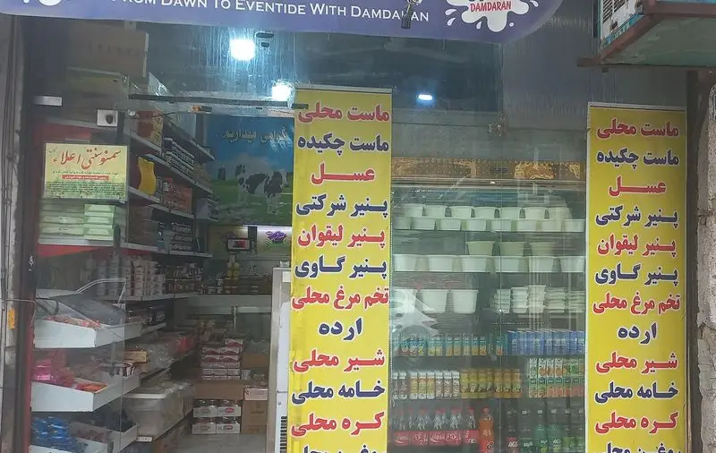 تصویر ورودی فروشگاه لبنیات سنتی سلامت ۲، با تابلو لیست محصولات محلی شامل ماست، پنیر، شیر، کره، خامه، عسل و تخم مرغ.