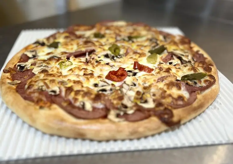 پیتزا مخصوص تازه و خوشمزه از پی پزا با قارچ، سوسیس، فلفل دلمه و پنیر طلایی. ایده‌آل برای سفارش آنلاین و لذت‌بردن از غذای باکیفیت.