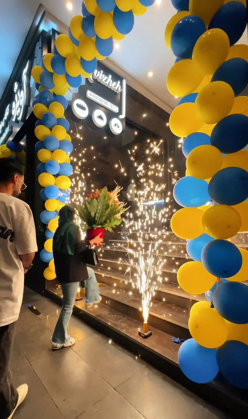 افتتاحیه باشکوه رستوران آویژه با بادکنک‌آرایی آبی و زرد، نورافشانی ورودی و استقبال از مهمانان. تجربه طعم‌های جدید در آویژه.