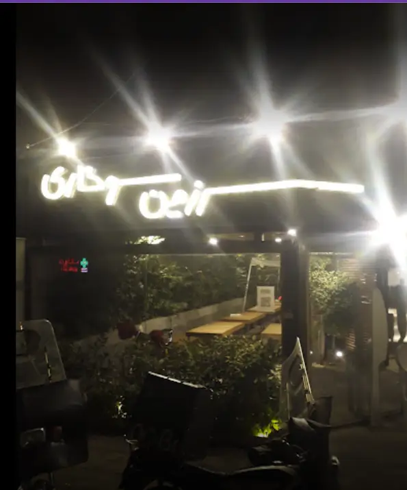 نمای بیرونی رستوران فست فود "سرزمین سوخاری" در شب با تابلوی نئون روشن و محیطی جذاب، مناسب برای سفارشات حضوری و دلیوری.