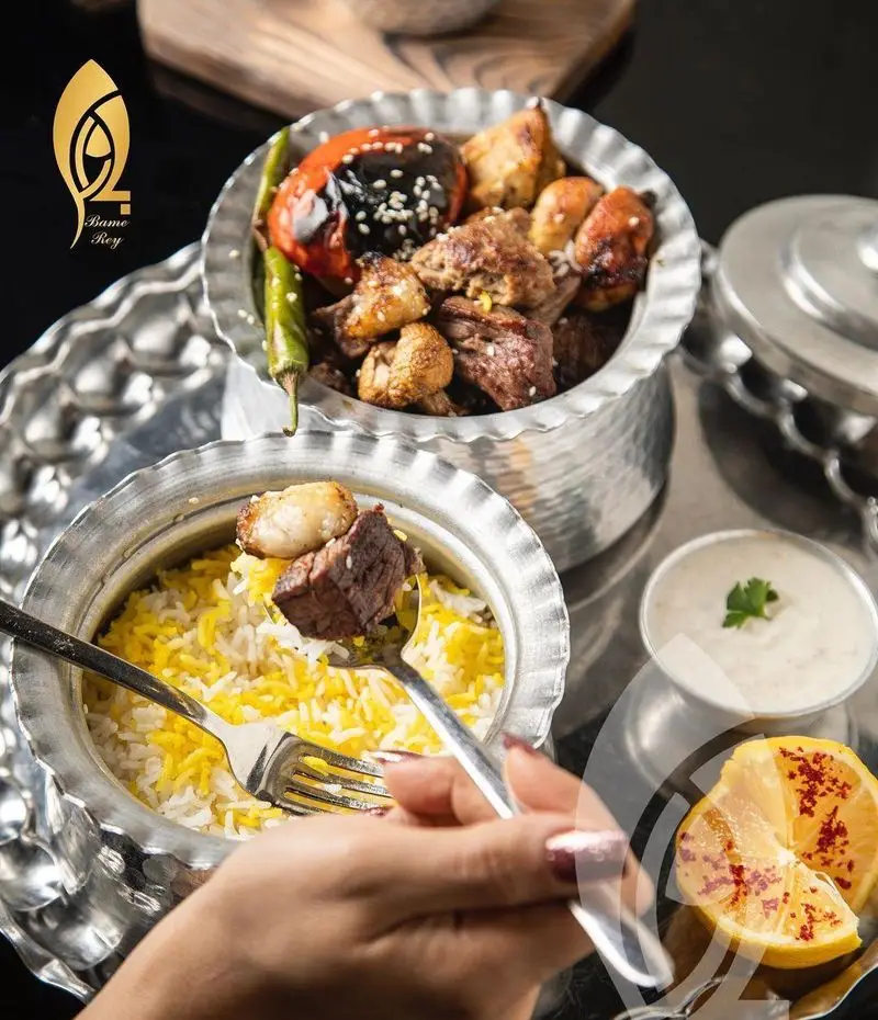 تجربه طعم دلنشین غذاهای اصیل ایرانی با کباب و پلو در ظروف سنتی زیبا در کافه رستوران بام ری، یک لذت بصری و ذائقه‌ای.