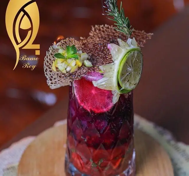 کوکتل میوه ای فصلی و بسیار دلنشین کافه رستوران بام ری با رنگ های زنده و تزئینات خاص لیمو، رزماری و تکه های میوه.