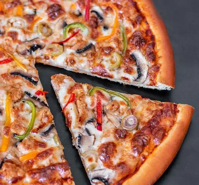 پیتزا قارچ، فلفل دلمه و زیتون خوشمزه از رستوران درخت ژینکو. بهترین پیتزای ایتالیایی با پنیر فراوان و نان تازه.