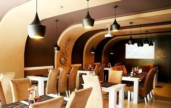 فضای داخلی لوکس رستوران درخت ژینکو: دکوراسیون مدرن و گرم با سقف‌های قوسی، میز و صندلی‌های شیک و نورپردازی جذاب.