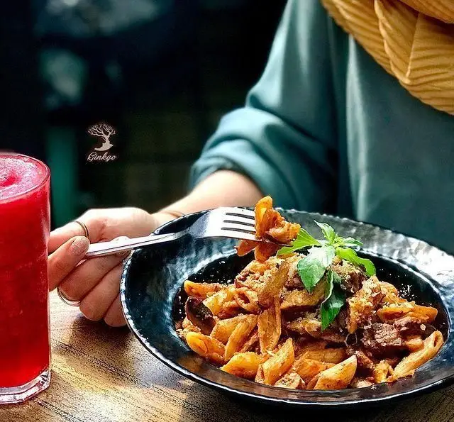 تجربه غذایی عالی در رستوران درخت ژینکو: پاستا با سس مخصوص، گوشت و سبزیجات تازه، در کنار نوشیدنی خنک و محیطی دلنشین.