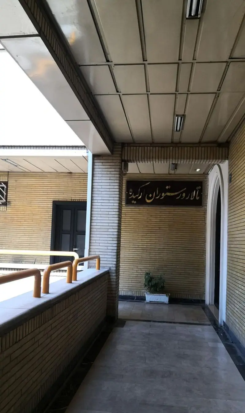 نمای ورودی جذاب و مدرن رستوران ارکیده طلایی، با دیوارهای آجری زرد و سقف کاذب، آماده پذیرایی از میهمانان.