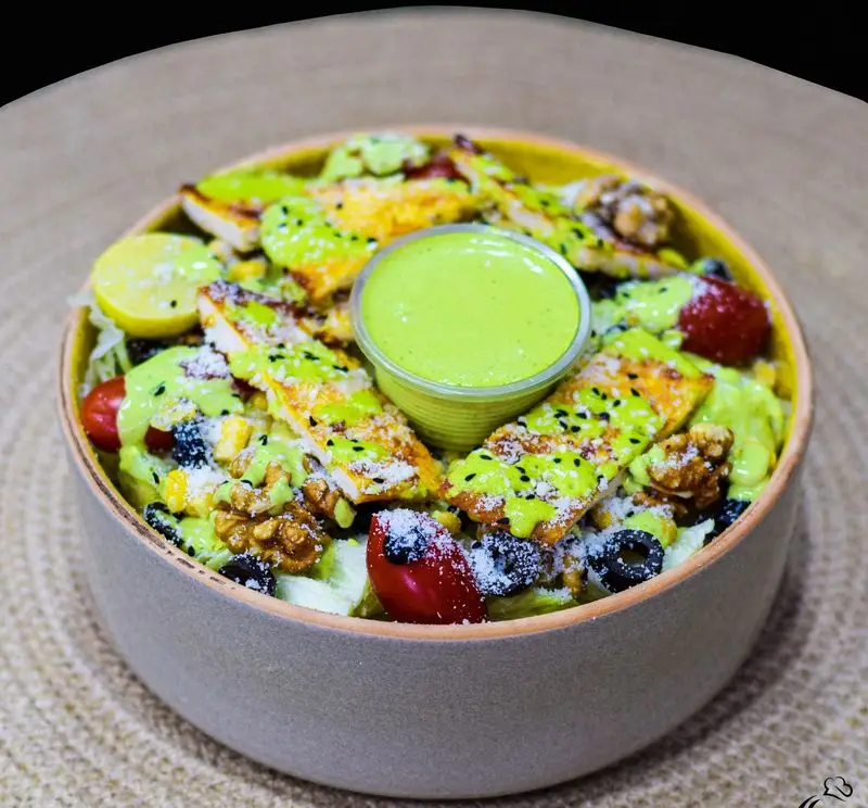 سالاد مرغ گریل با سس مخصوص سبز، گوجه، گردو و زیتون. غذای سالم و خوشمزه از منوی متنوع رستوران کترینگ آسمان.