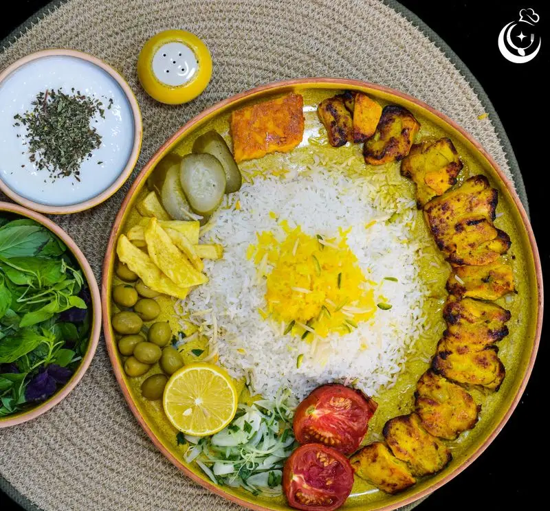 پلاتر غذای کامل رستوران کترینگ آسمان شامل چلو جوجه کباب، برنج زعفرانی، سالاد، ماست، زیتون و مخلفات لذیذ. سفارش آنلاین غذای ایرانی.