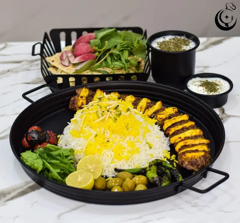 غذای اصیل ایرانی کترینگ آسمان: سینی کباب کوبیده، جوجه کباب، برنج زعفرانی با مخلفات متنوع و دوغ. تجربه‌ای لذیذ و باکیفیت.