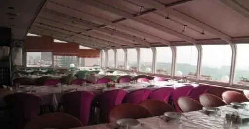 سالن غذاخوری دلباز و مدرن رستوران چلوکباب رفتاری با سقف شیشه‌ای، میزهای چیده شده و منظره شهری از پنجره‌ها.