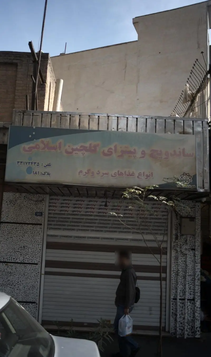 نمای بیرونی ساندویچ و پیتزای گلچین اسلامی با تابلو بزرگ، پلاک ۱۸۱ و شماره تلفن ۲۲۱۷۲۴۳۵، عرضه کننده انواع غذاهای سرد و گرم.