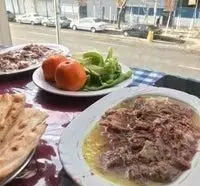 میز صبحانه کامل طباخی هوس با خوراک کله پاچه سنتی، گوشت کوبیده یا غذای گوشتی، سبزی تازه و نان داغ، مشرف به خیابان شهر.