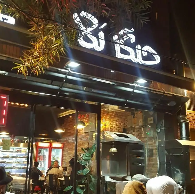 نمای شبانه رستوران جیگر بلا با تابلوی نئون روشن، مشتریان در حال صرف غذا، محیطی دلنشین برای کباب و جگر.