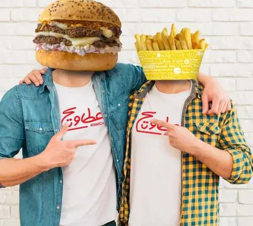 تبلیغ جدید و جذاب فست فود عطاویچ، شامل دو نفر با سر همبرگر و سیب زمینی سرخ کرده که به لوگوی عطاویچ اشاره می‌کنند.