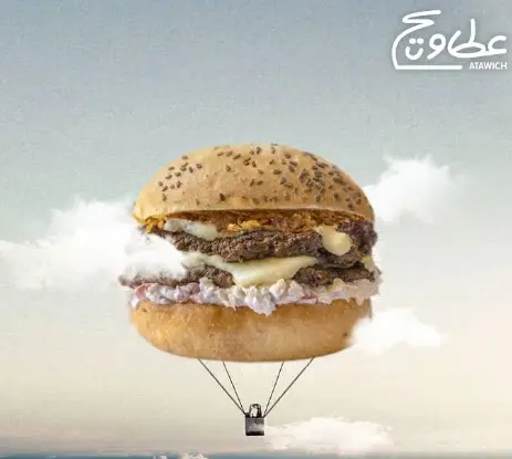 همبرگر پرواز کننده عطاویچ: یک همبرگر بزرگ دو طبقه مانند بالون هوای گرم در آسمان ابری شناور است. تبلیغ عطاویچ فست فود.