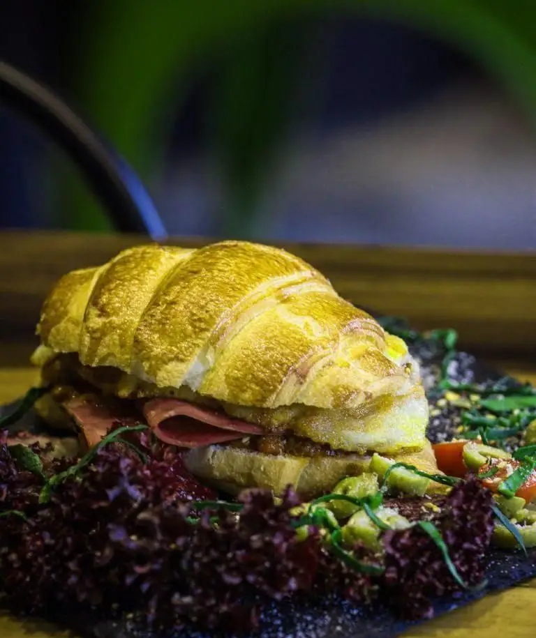 کروسان ساندویچ ویژه و لذیذ کافه وصال، با ژامبون، تخم مرغ و سس مخصوص، همراه سالاد کاهو و زیتون. تجربه طعمی متفاوت در کافه وصال.