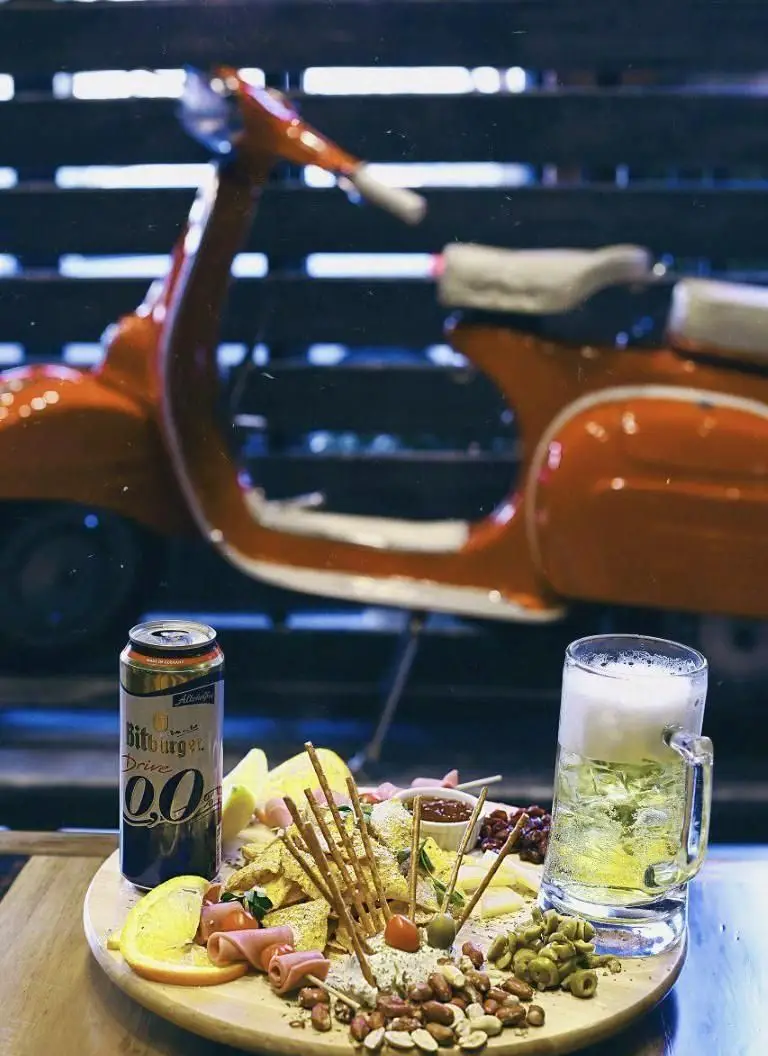 بشقاب مزه لذیذ کافه وصال با آبجو غیرالکلی Bitburger 0.0، نوشیدنی خنک و اسکوتر نارنجی؛ فضایی عالی و دوستانه.